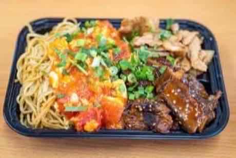 Catering tray with lo mein, tomato and egg, wok-fried chicken and braised ribs