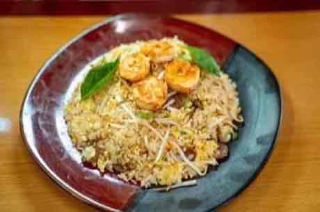Shrimp fried rice served on a red and black plate