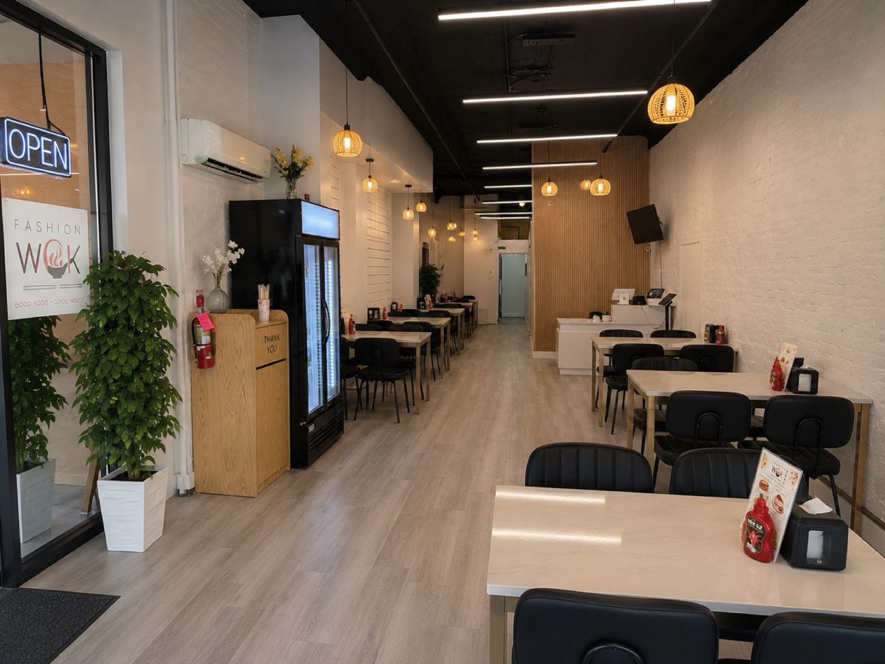 Bright, freshly remodeled Fashion Wok dining room with modern seating and warm pendant lighting